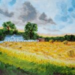 The golden hues of a field, rich and warm, stretch out to meet a sky painted with soft blues and whites